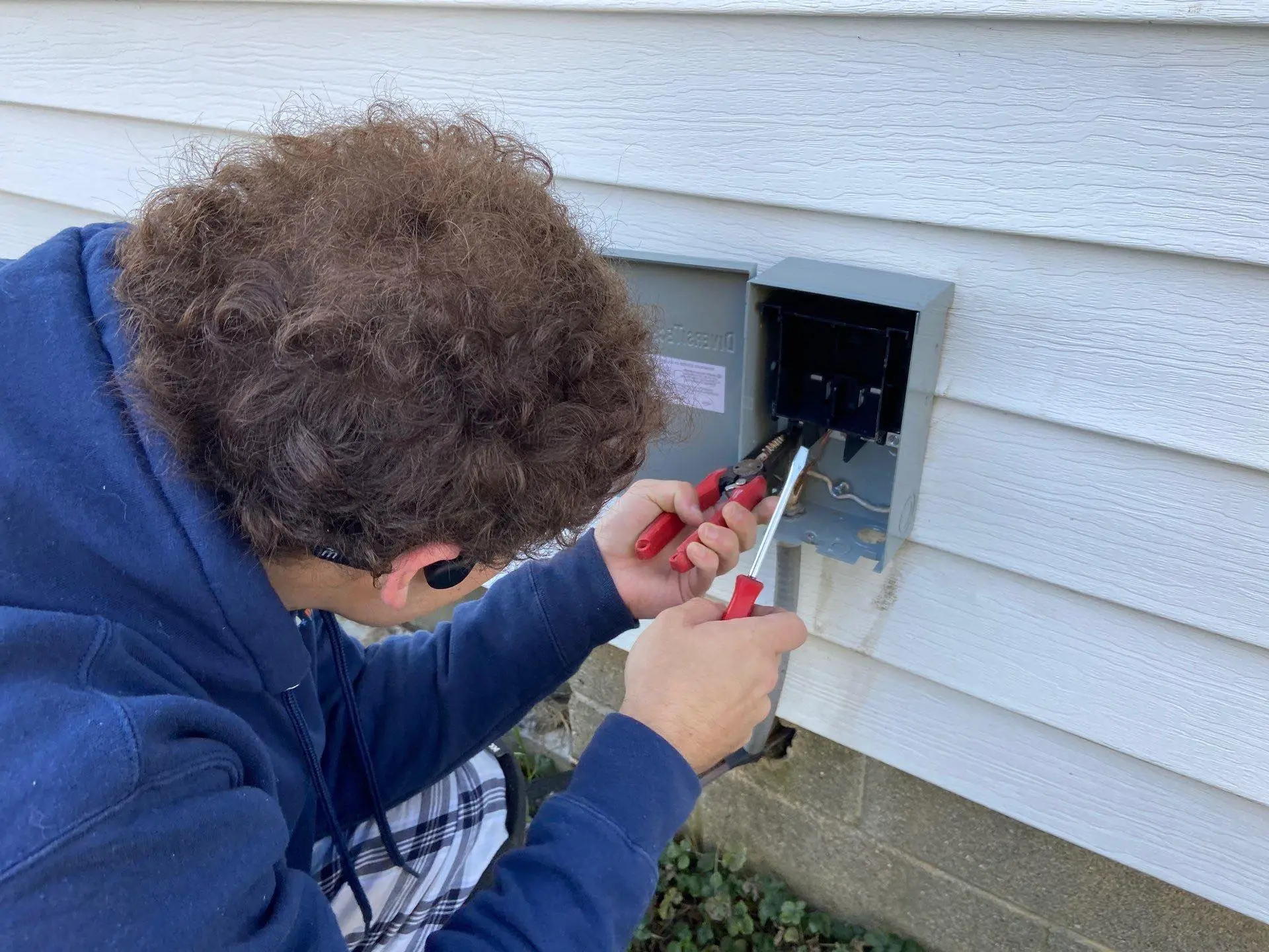 Tech inspecting an AC electrical disconnect at a Clayton-area property